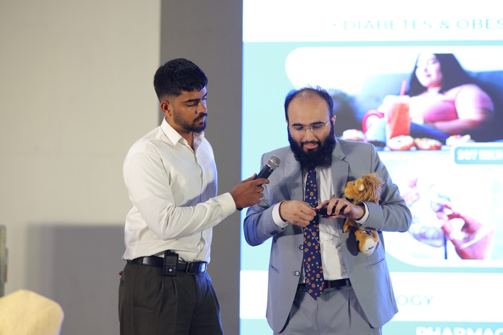 Dr Khizer with a child on stage